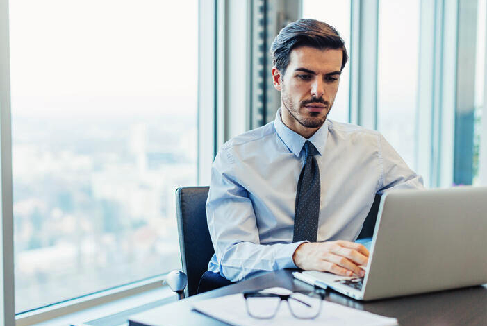 empreendedor sentado em seu escritório de frente para o computador onde ele emite uma procuração eletrônica